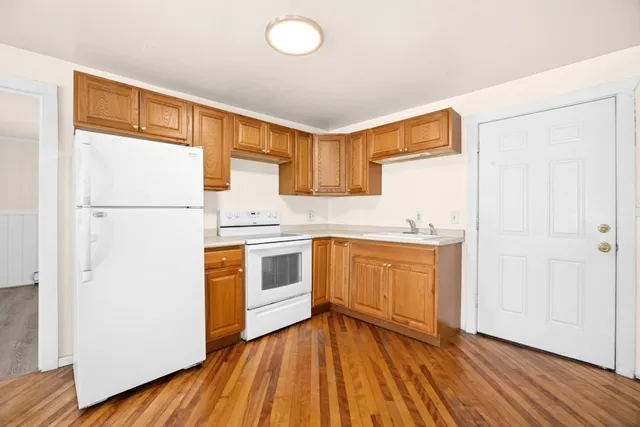 a kitchen with white cabinets and white appliances