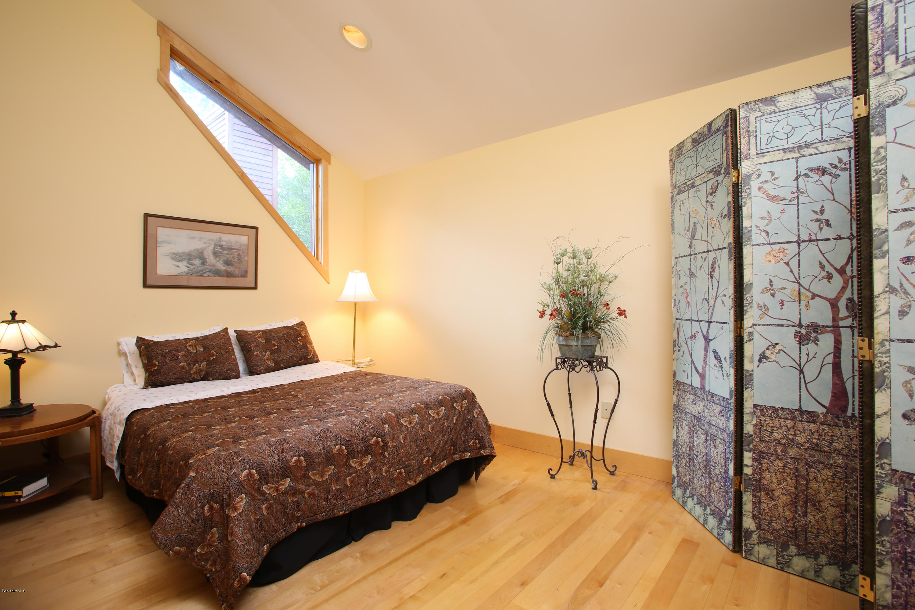 108 Valley View Road Becket, MA 01223 - Photo 17 of 35 a bedroom with a bed table and a chandelier