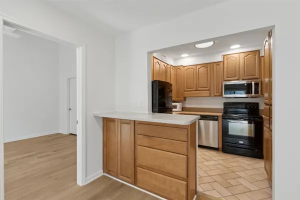 a kitchen with kitchen island white cabinets and stainless steel appliances