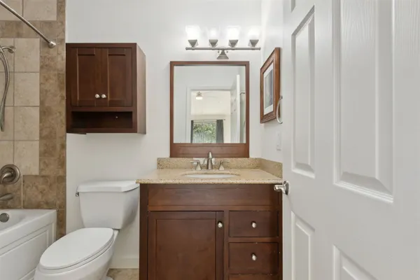 a bathroom with a toilet a sink a vanity and mirror