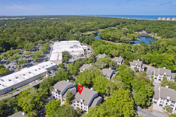 an aerial view of residential house with outdoor space and trees all around