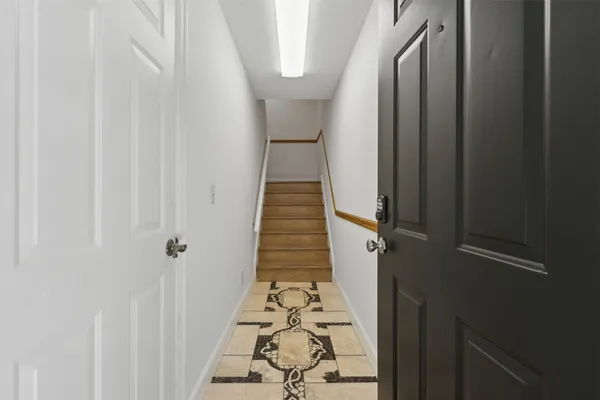 a view of a hallway with wooden floor and staircase