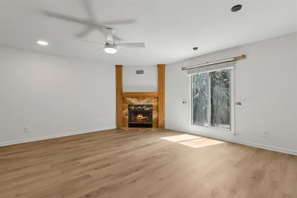 a view of an empty room with a fireplace and a window