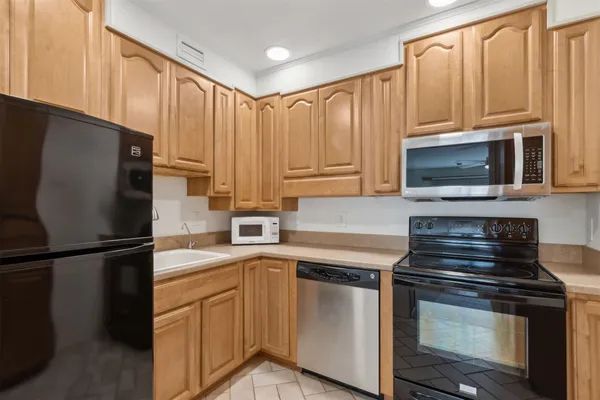 a kitchen with granite countertop a refrigerator stove and microwave