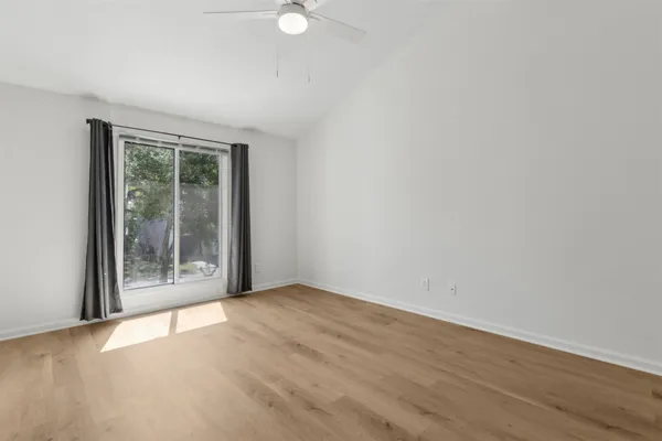 an empty room with wooden floor and windows