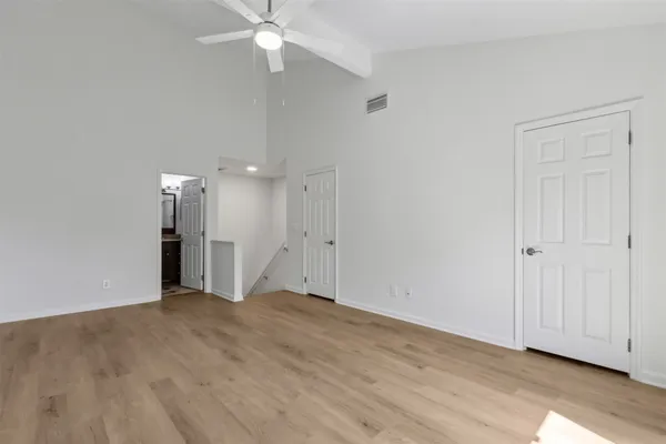 a view of an empty room with wooden floor