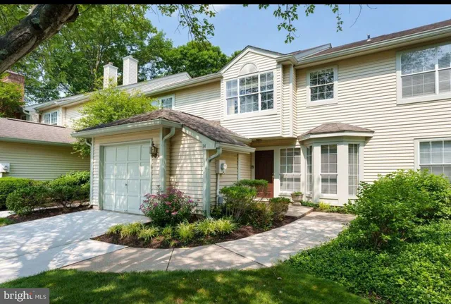 a front view of a house with a yard and potted plants