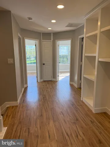 an empty room with wooden floor and a window