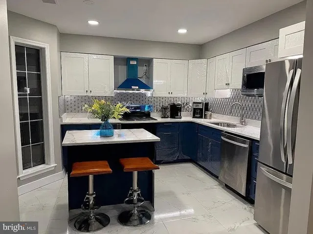 a kitchen with stainless steel appliances a sink cabinets and wooden floor