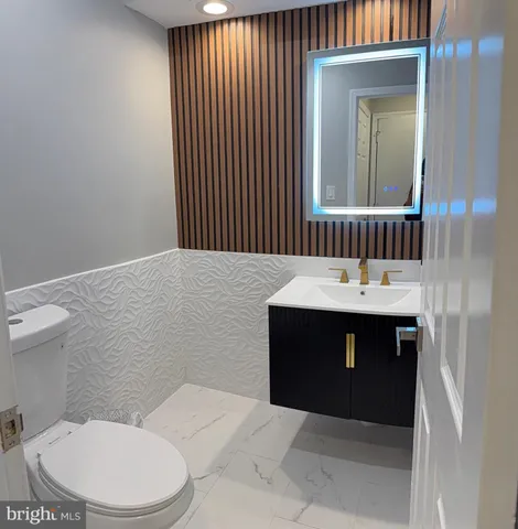 a bathroom with a sink vanity mirror and toilet
