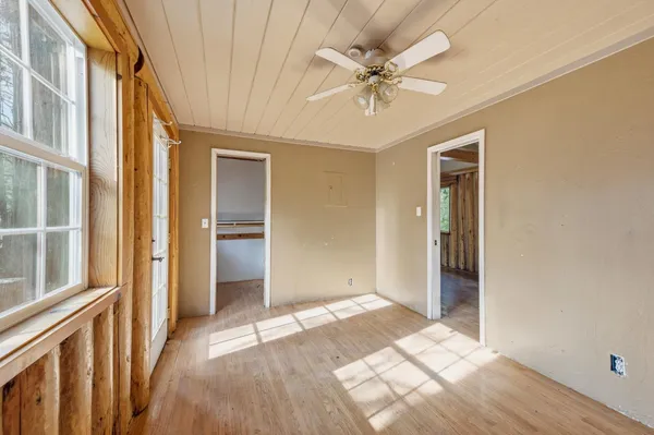 en empty room with windows and ceiling fan
