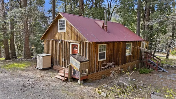 a view of a house with backyard and trees
