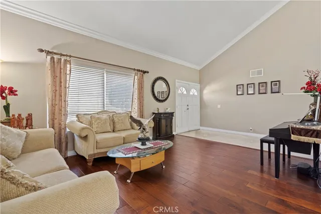 a living room with furniture a window and wooden floor