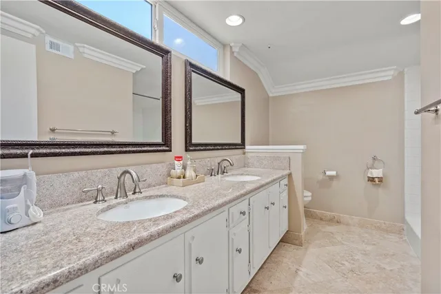 a bathroom with a granite countertop sink double and mirror