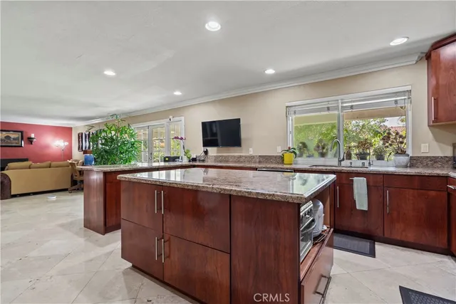 a kitchen with kitchen island granite countertop a stove and a sink