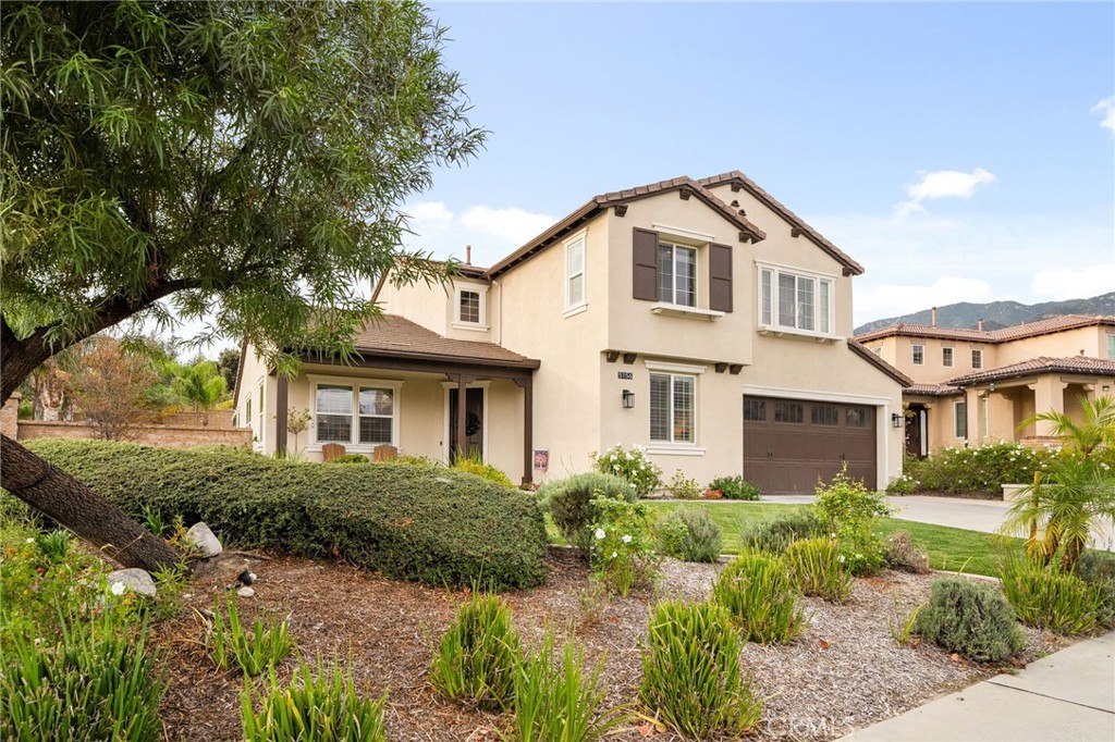 5156 Tahoe Place Rancho Cucamonga, CA 91739 - Photo 48 of 49 a view of a white house next to a yard with plants and trees