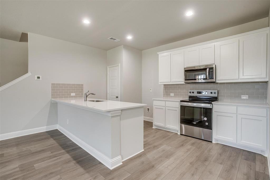 6807 Robert Reed Drive Arlington, TX 76001 - Photo 13 of 37 a kitchen with sink a microwave and cabinets