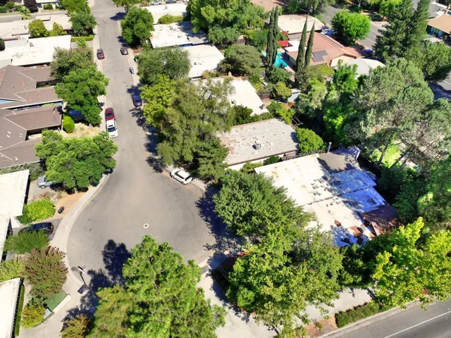 an aerial view of residential house with outdoor space and trees all around