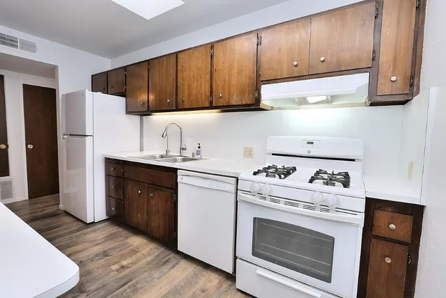 a kitchen with stainless steel appliances granite countertop a stove a refrigerator and a cabinets