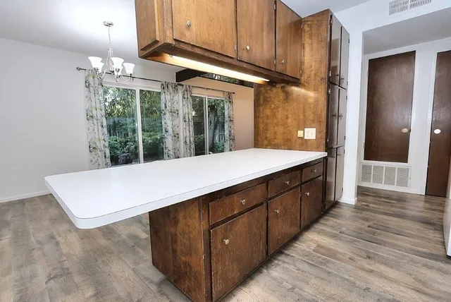 a kitchen with kitchen island a counter top space a sink and cabinets