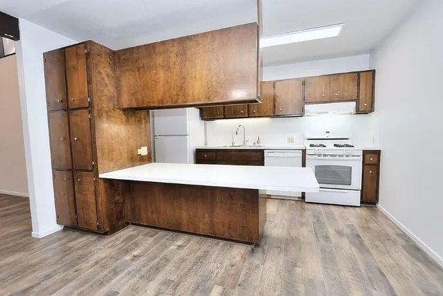 a kitchen with stainless steel appliances a sink a stove a refrigerator and cabinets