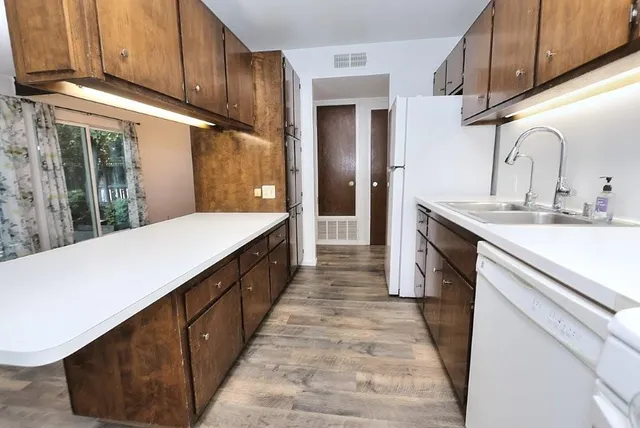 a kitchen with kitchen island granite countertop a sink and refrigerator