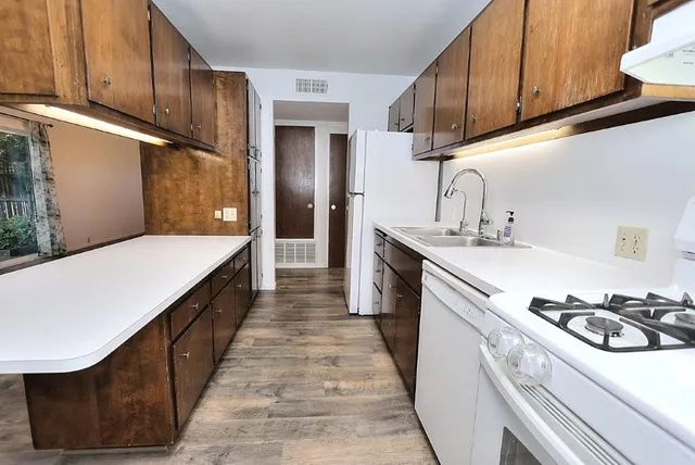 a kitchen with kitchen island granite countertop a sink and refrigerator