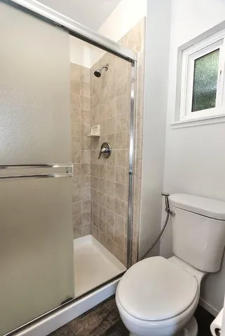 a white toilet sitting next to a bath tub and a shower