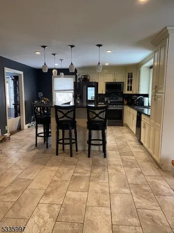 a kitchen with stainless steel appliances kitchen island granite countertop a sink a counter top space and cabinets
