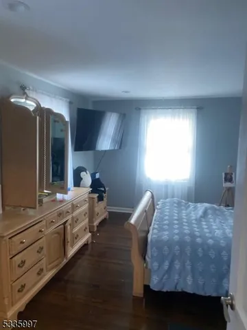 a bedroom with a bed and a large mirror on the dresser