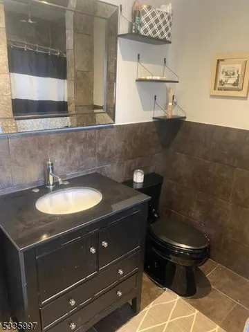 a bathroom with a granite countertop sink a toilet and a mirror