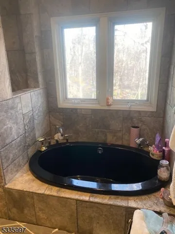 a bath tub sitting in a bathroom next to a window