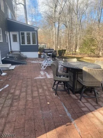 a view of backyard with table and chairs and potted plants
