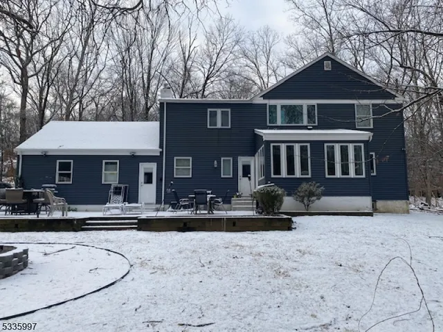 a front view of a house with a yard covered in snow