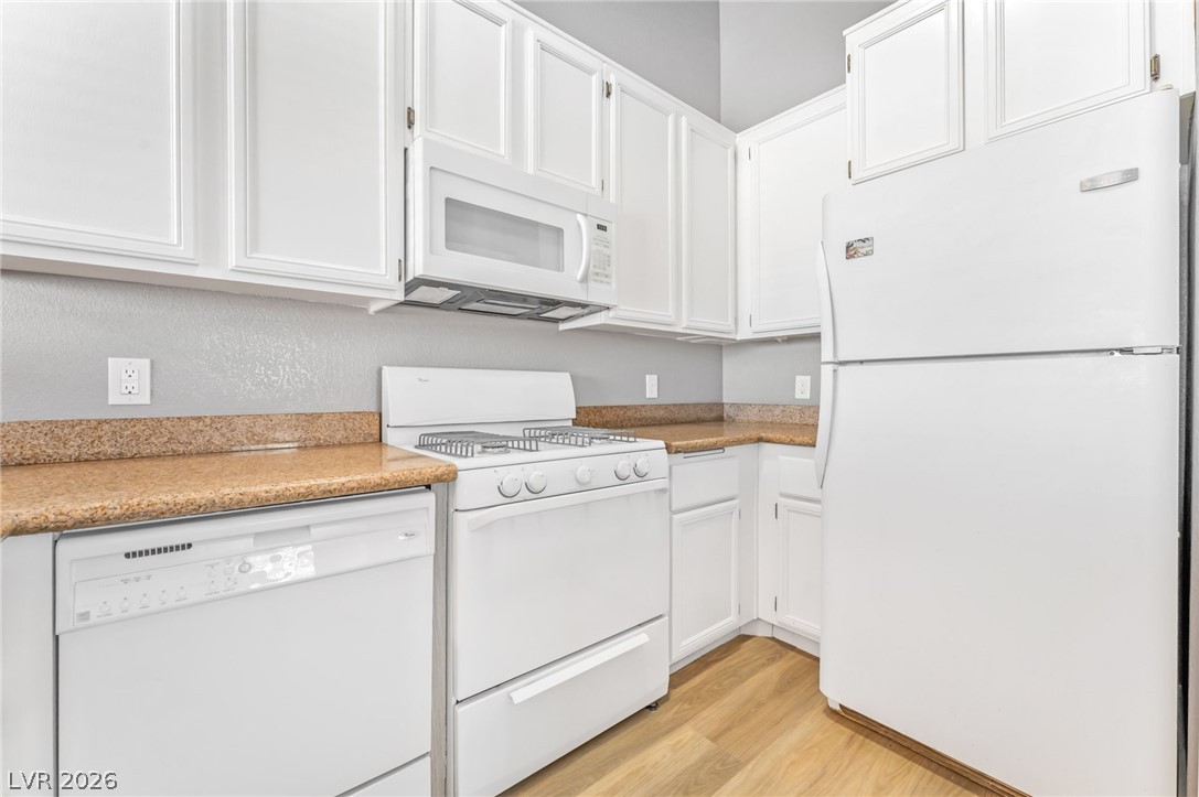 3318 North Decatur Boulevard, Unit 2152 Las Vegas, NV 89130 - Photo 12 of 58 Functional kitchen with ample cabinet space, laminate countertops, and essential appliances for everyday living.