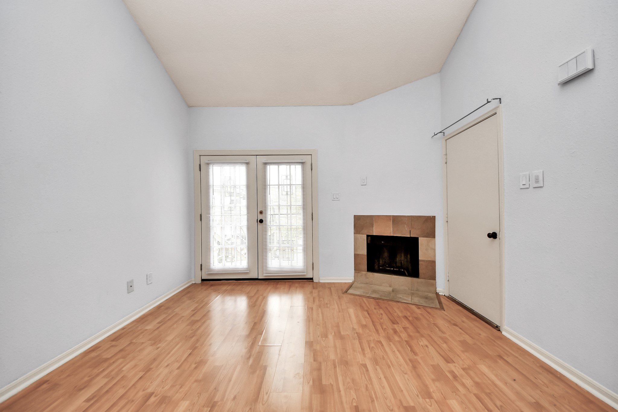 2425 Holly Hall Street, Unit C54 Houston, TX 77054 - Photo 3 of 24 an empty room with wooden floor fireplace and windows