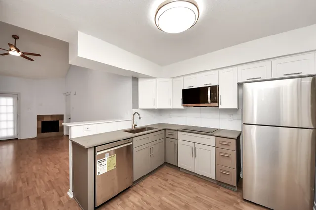 a kitchen with a sink a refrigerator a microwave and cabinets