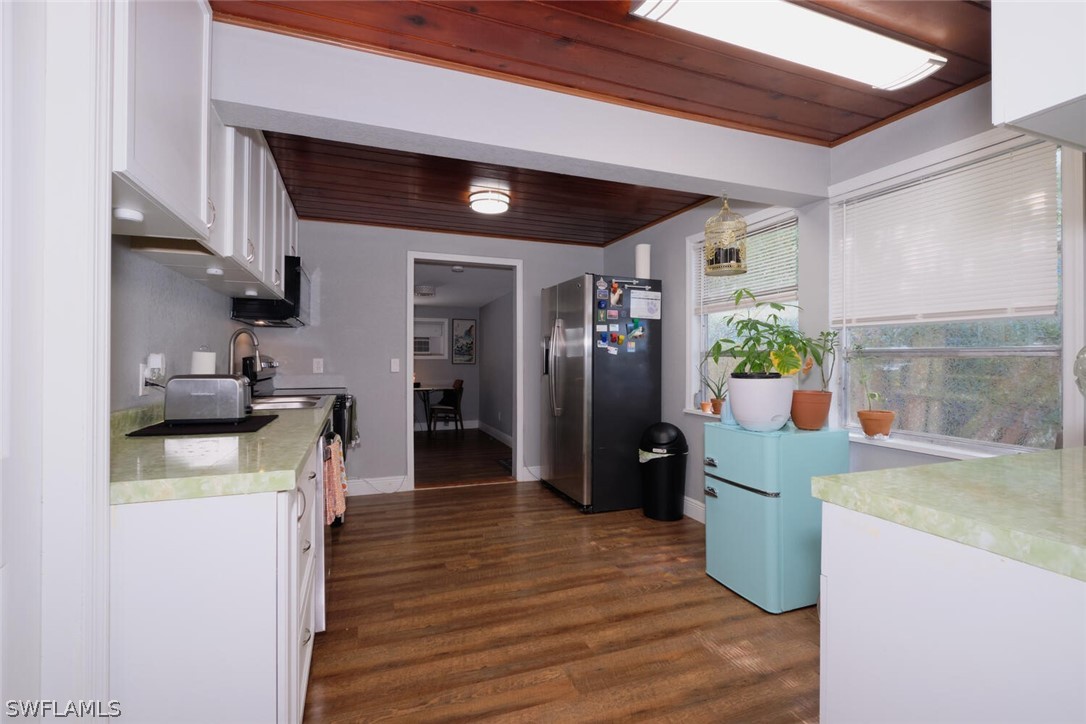 1322 Old Bridge Road North Fort Myers, FL 33917 - Photo 4 of 15 a kitchen with stainless steel appliances kitchen island granite countertop a refrigerator a stove and a wooden floors
