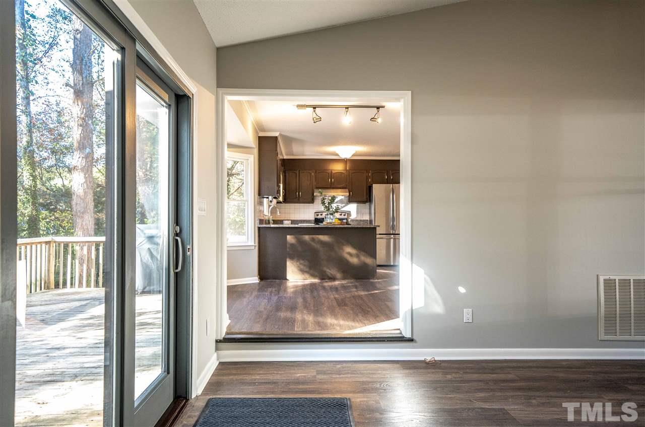 516 Merrie Road Raleigh, NC 27606 - Photo 6 of 29 a view of a hallway with wooden floor and living room