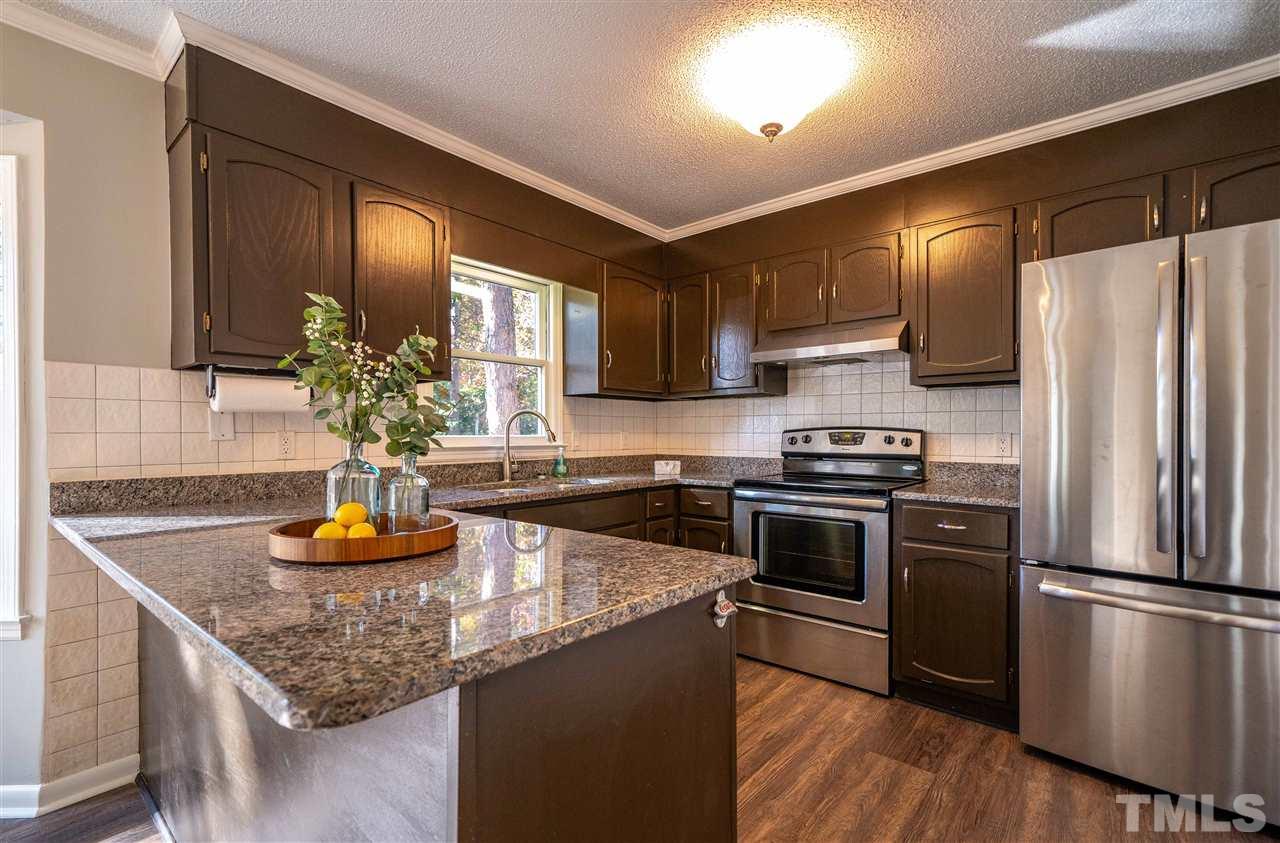 516 Merrie Road Raleigh, NC 27606 - Photo 9 of 29 a kitchen with a refrigerator and a sink