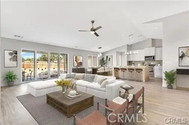 a living room with furniture kitchen view and a large window