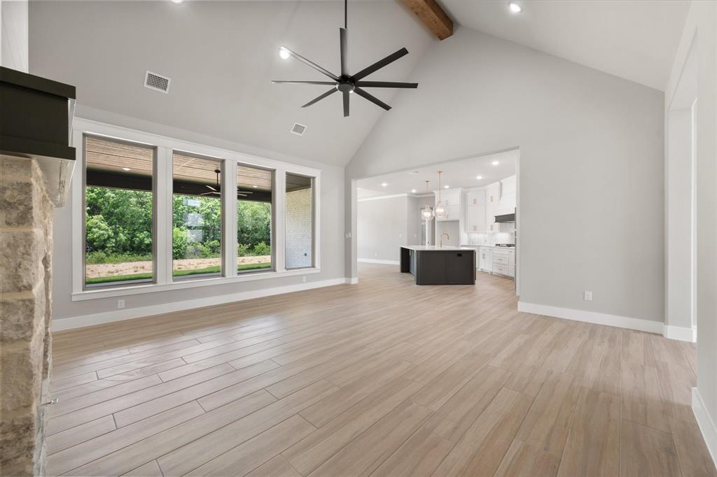 6610 Waggoner Way Midlothian, TX 76065 - Photo 9 of 40 Spacious living area featuring vaulted ceilings with exposed wood beam, recessed lighting, and a contemporary ceiling fan