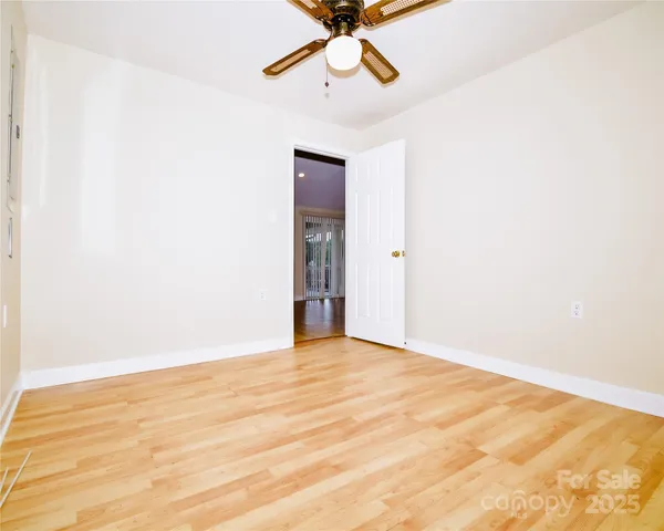 a view of an empty room with a chandelier fan