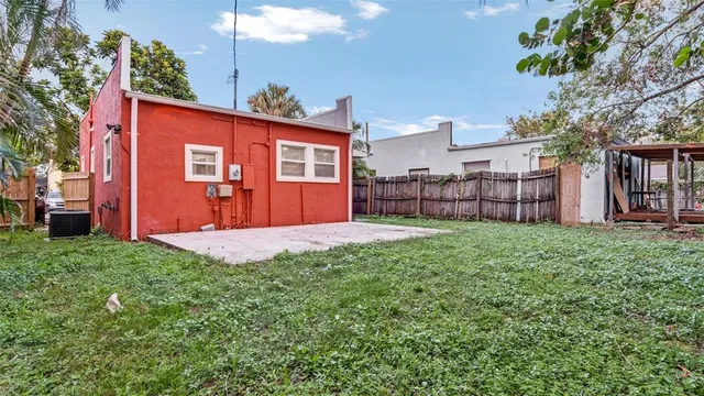 a view of a backyard with large trees and a barn