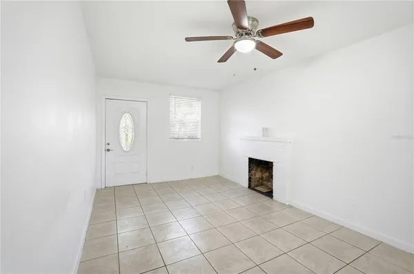 an empty room with windows and fireplace