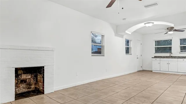 an empty room with windows and fireplace