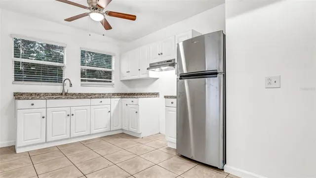 a kitchen with stainless steel appliances granite countertop a refrigerator and a sink