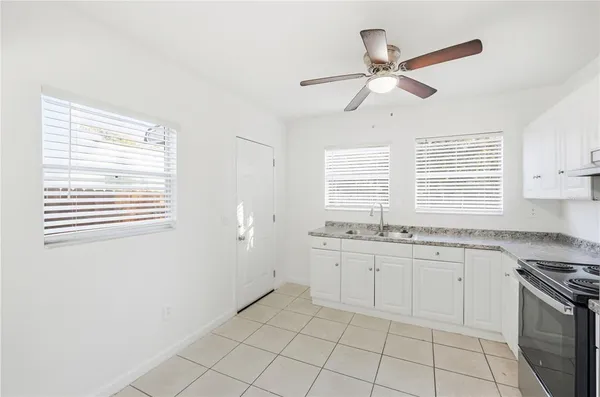 a kitchen with a stove a sink and a window