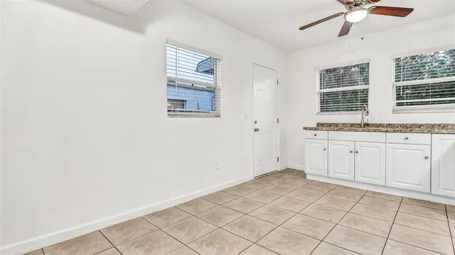 a view of a kitchen with white cabinets appliances and a window