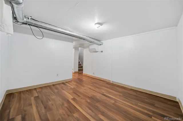a view of a room with wooden floor and white walls